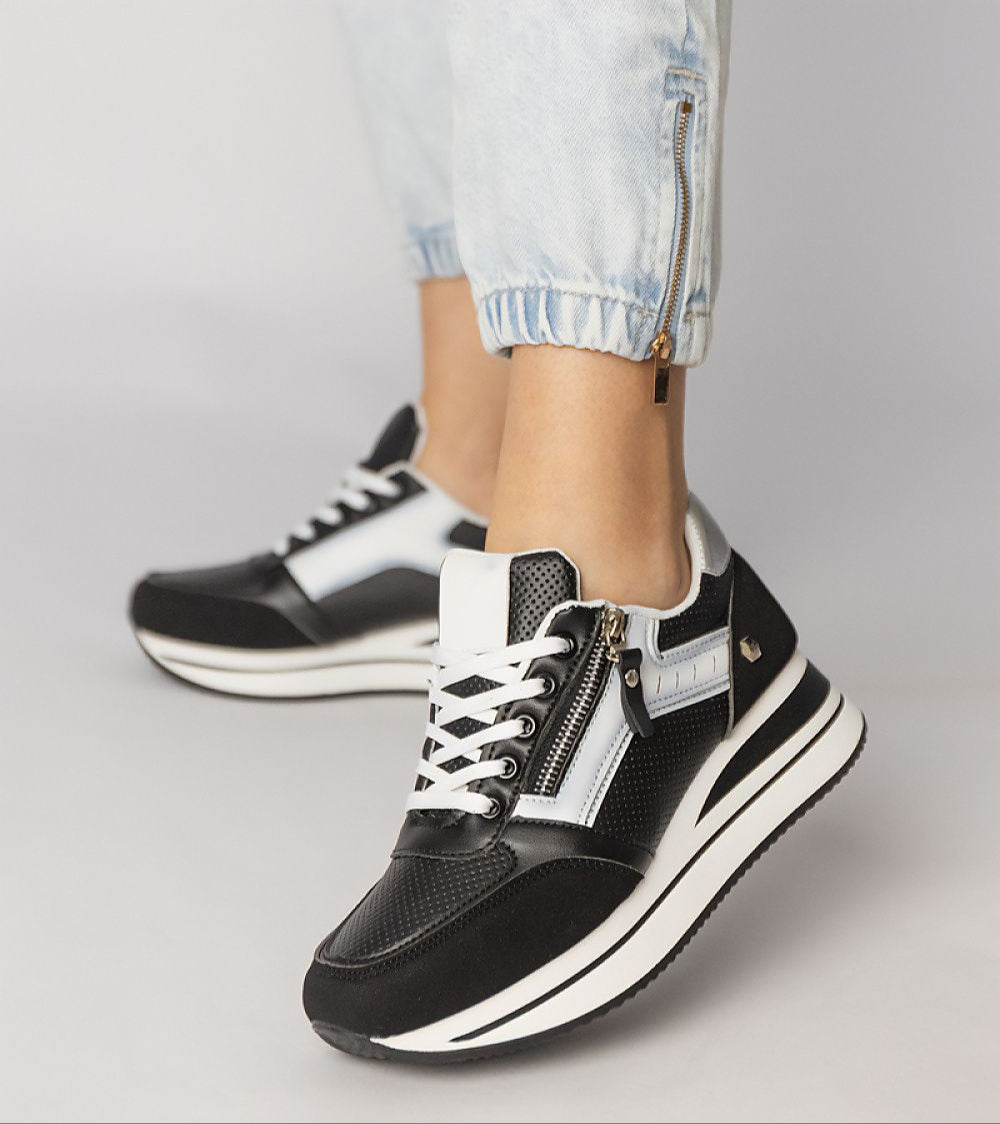 Vorelle zip-up sneakers in black with decorative side zipper, worn with light denim, showcasing casual sporty style and elevated platform.