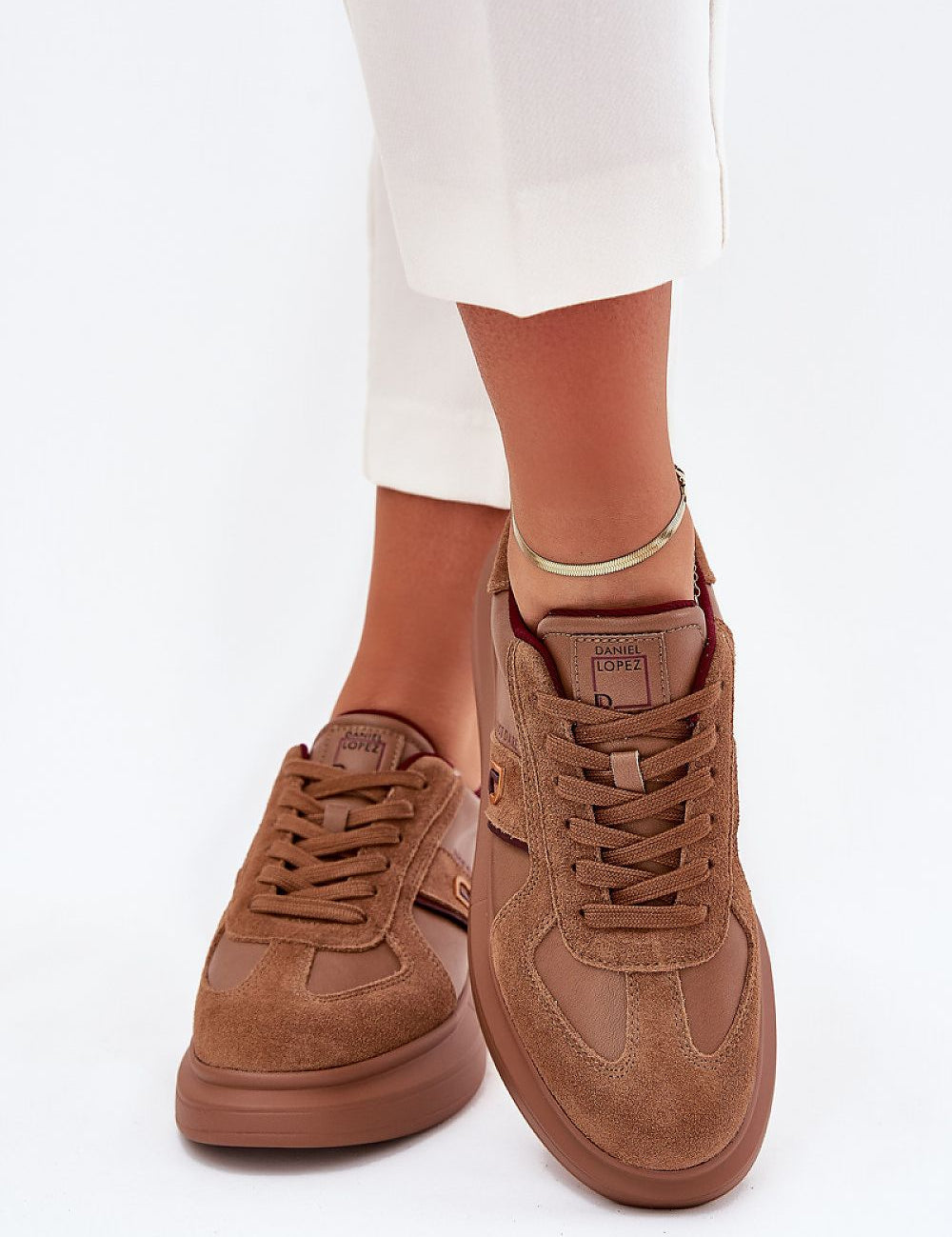 Brown Caravelle Mixed-Leather Sneakers with suede finish and platform sole, worn by a person in white pants. Fashion footwear.