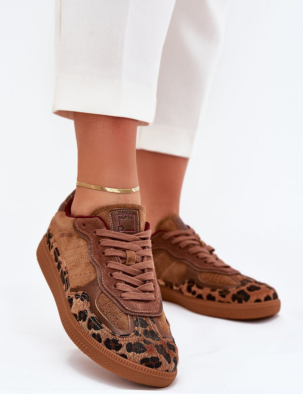 Brown suede sneakers with leopard print and white pants