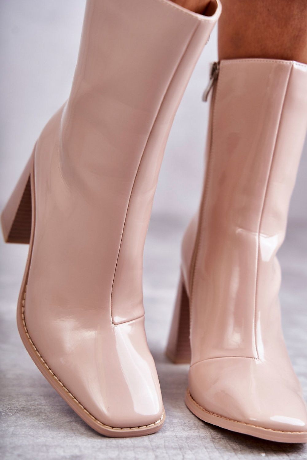 Glossy beige mid-calf boots with a lacquered finish, featuring a pointed toe and slim stiletto heel, crafted from eco leather.