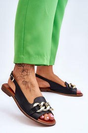 Dorellia Leather Flat Sandals with chain detail and adjustable ankle strap, worn with green pants, showcasing comfort and style.