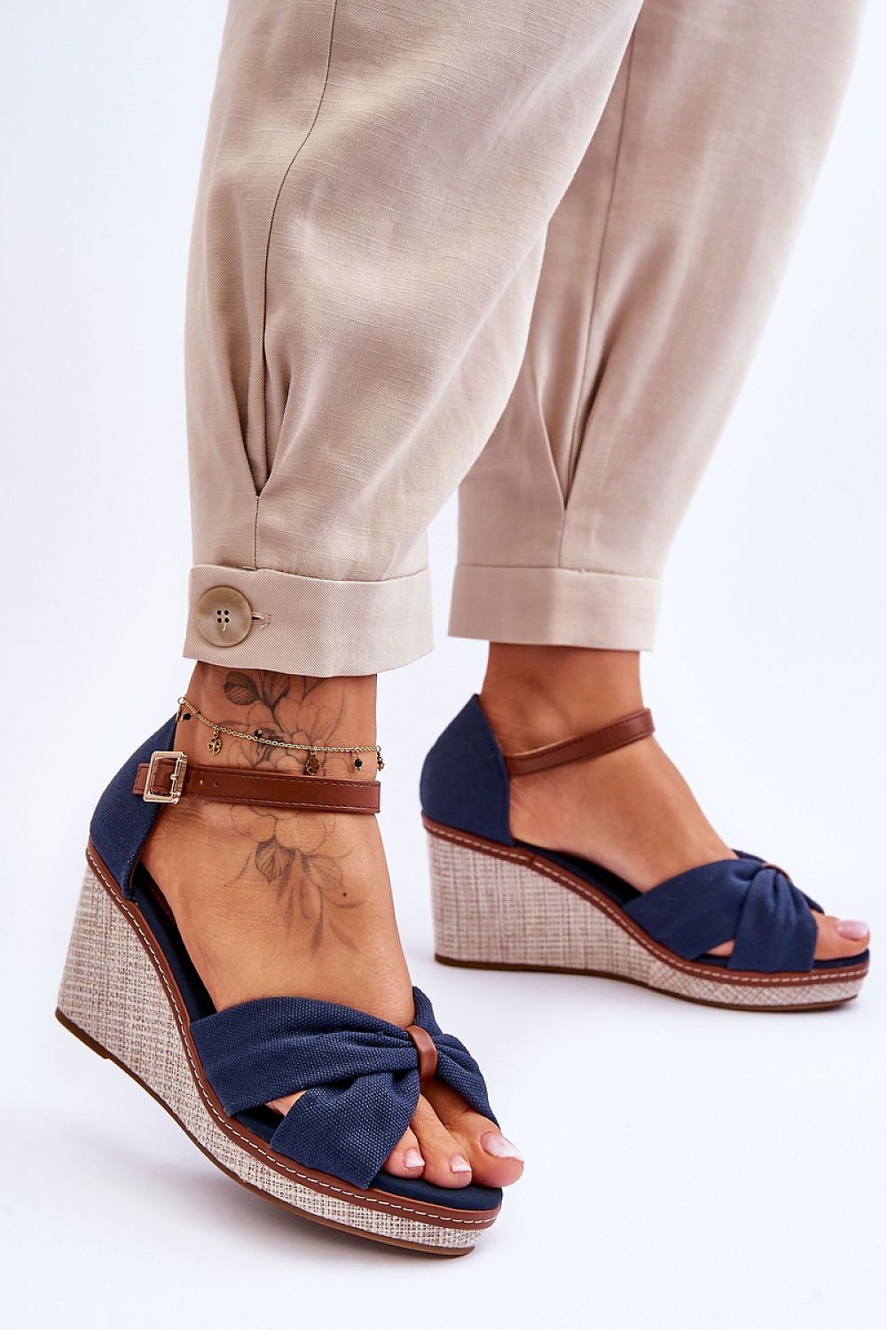 Woman wearing Larvella Woven Fabric Buskins, showcasing stylish blue woven sandals with a sculpted heel and buckle-fastened ankle strap.
