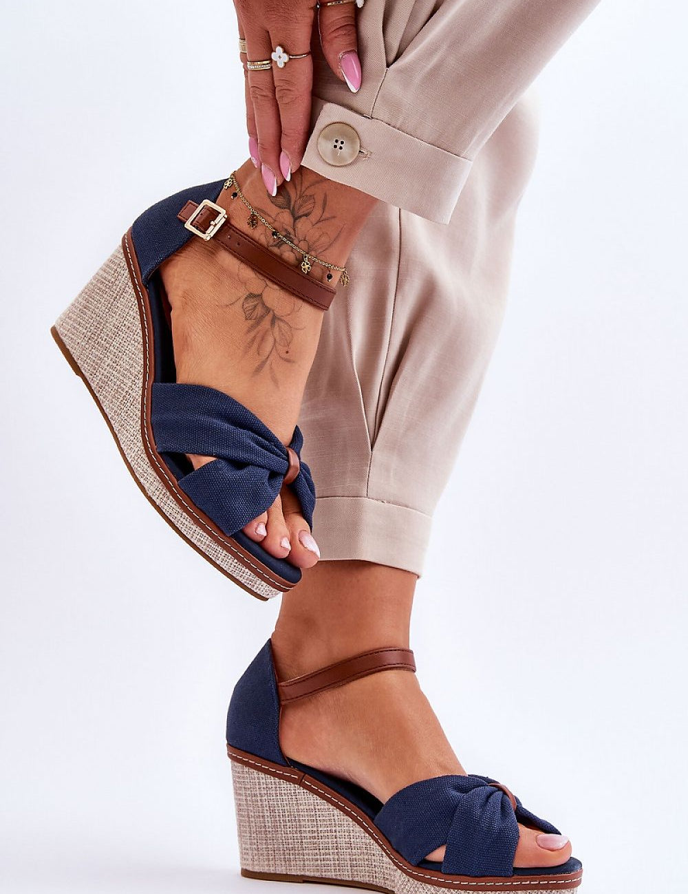 Larvella woven fabric buskins with buckle ankle strap, non-slip sole, and sculpted heel in blue, worn with beige trousers.