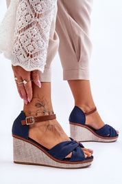 Woman wearing Larvella Woven Fabric Buskins, blue fabric sandals with a wedge heel, ankle strap, and non-slip sole.