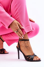 Woman in pink outfit wearing Astella Strappy Tie-Up Heels with stiletto heel, showcasing elegant tie-up and adjustable ankle strap.