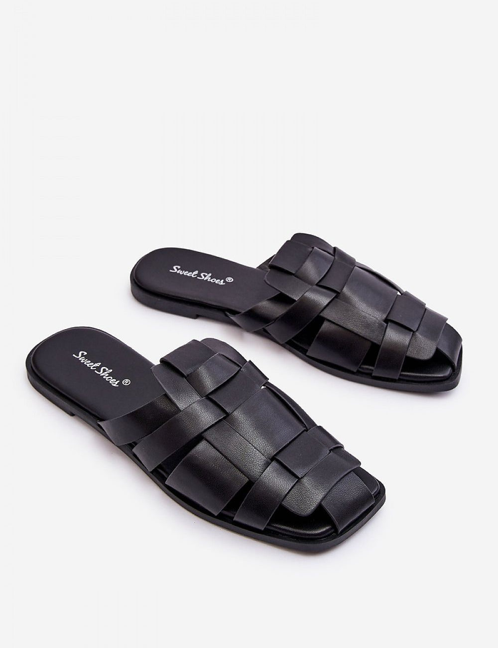 Black woven slip-on flat flip-flops with cushioned insole on a white background.