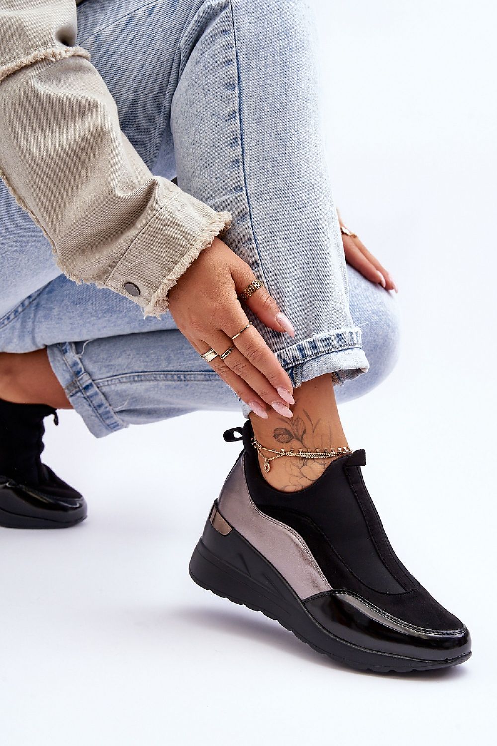 Woman wearing Lestora Dual-Layer Slip-On Sneakers in black and gray, paired with jeans, showcasing stylish comfort and modern design.