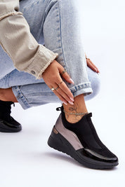 Woman wearing Lestora Dual-Layer Slip-On Sneakers in black and gray, paired with jeans, showcasing stylish comfort and modern design.