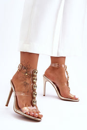 Woman wearing Astrielle High-Heel Crystal Sandals with rhinestone embellishments and transparent upper.