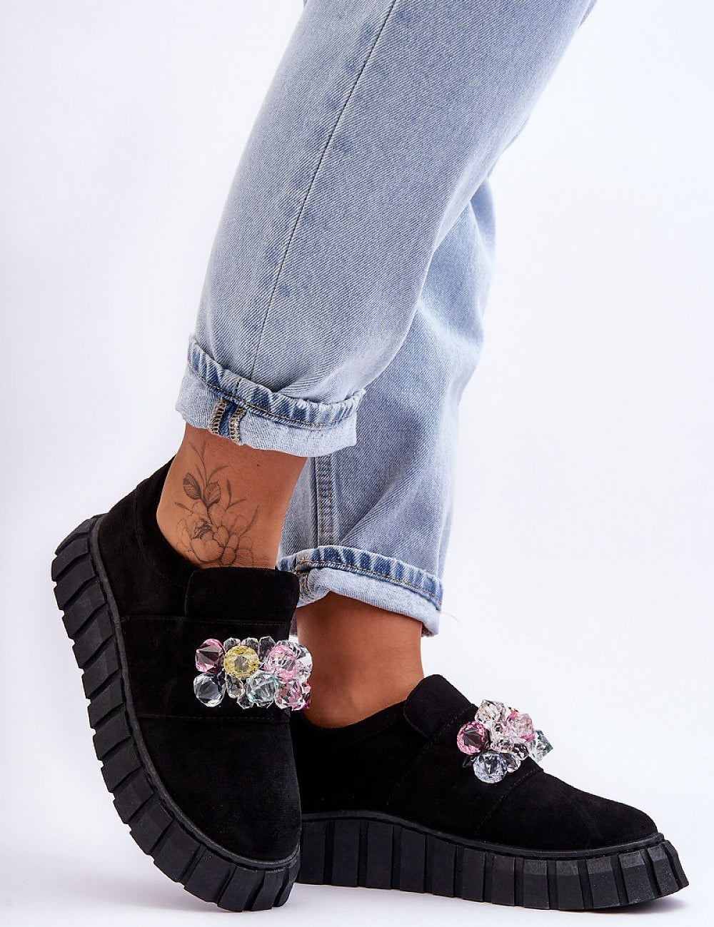 Woman wearing Verelune Crystal Platform Slip-Ons with eco-suede texture and sparkling crystal accents, showcasing chic, comfortable style.