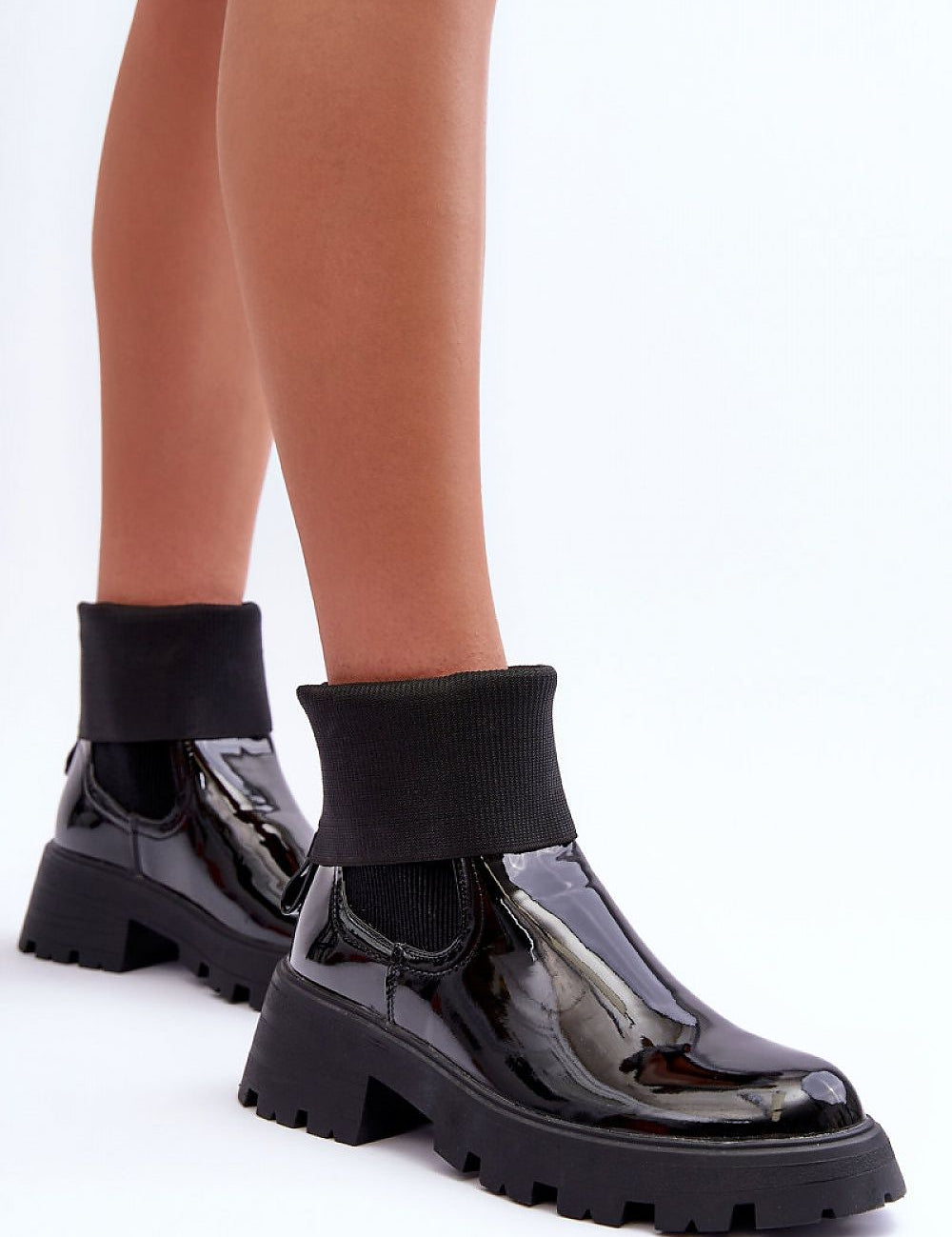 Woman wearing Arminne Chunky Ankle Boots in black eco leather with elastic inserts, thick platform, and block heel for stylish city looks.