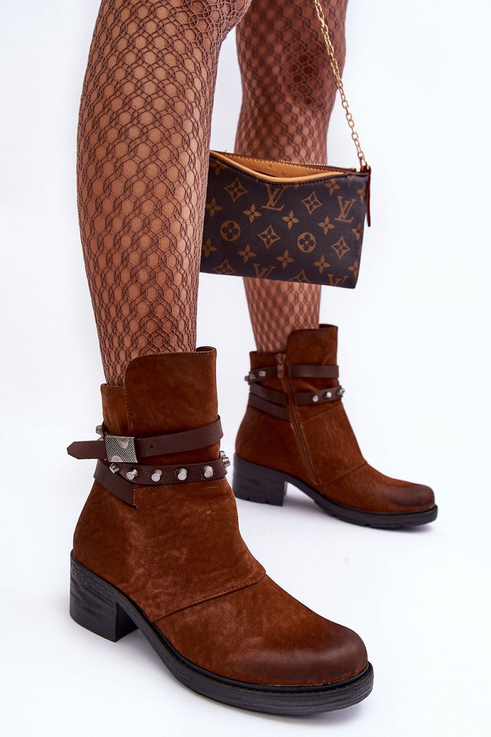 Woman wearing Morena Matte Vegan Leather Boots paired with patterned tights and holding a designer clutch.